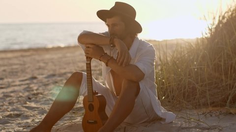 Man With Ukulele During Summer Beach Vacation Near the Sea