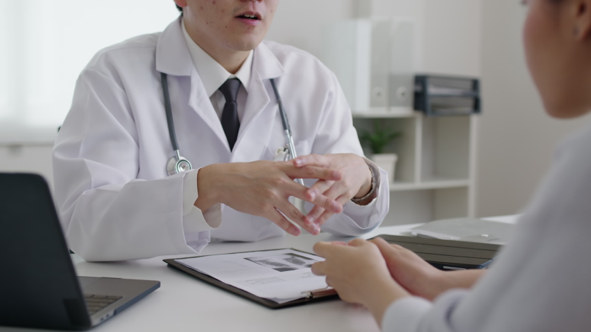 Friendly medic service people or asia male help talk discuss of medical exam record test result at clinic office desk. Young sad serious stress woman visit, follow , listen, see doctor at hospital. | Shutterstock HD Video #1076041004