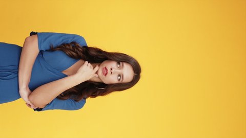 Advertising people. Aha idea. Solution insight. Portrait of pensive inspired woman pointing up finger at something invisible isolated on bright orange copy space vertical background.