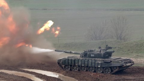 Military Army Tank Shooting in the  dirt. Combat fighting heavy armored vechicle firing. Modern war battle shoot of tank muzzle flash. Russian invaders in Ukraine