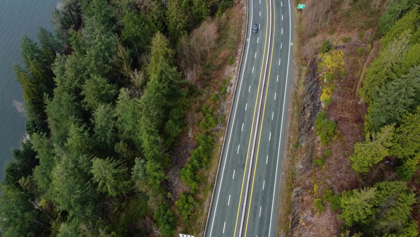 Top down view of Canadian highway by the mountain with green spruce trees