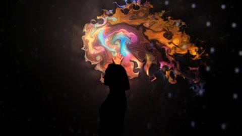 Girl plays with an interactive video installation. New art form, generative graphics. Silhouette of girl draws with her hands in multicolored colors interactive installation on wall