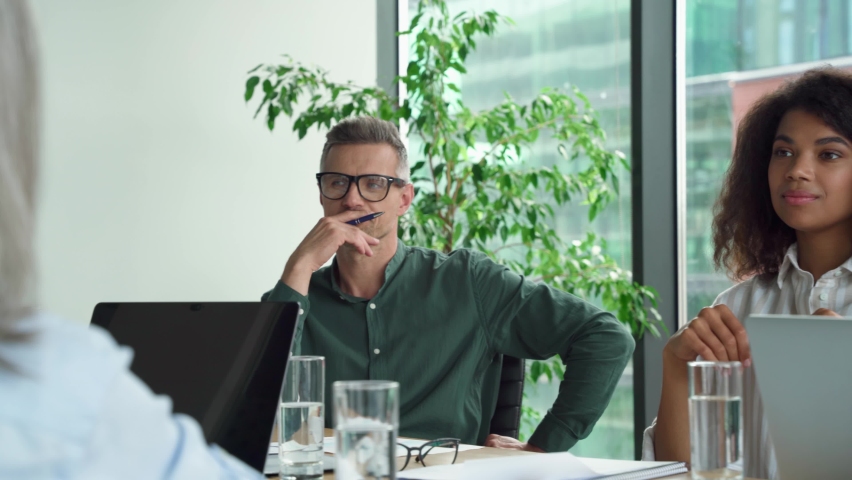 Diverse business people partners group negotiating at boardroom meeting. Multiethnic executive team discussing financial partnership contract project strategy brainstorming sitting at table in office. | Shutterstock HD Video #1076059664