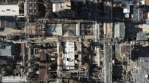 Aerial top down view of oil refinery plant, metal pipes in industry zone late afternoon light with long shadows