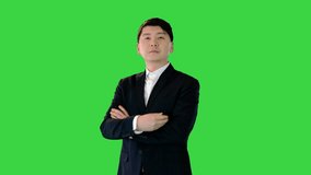 Asian man stands adjusting his suit and crossing arms on a Green Screen, Chroma Key. - Powered by Shutterstock - Get 15% off with code: PIKWIZARD15