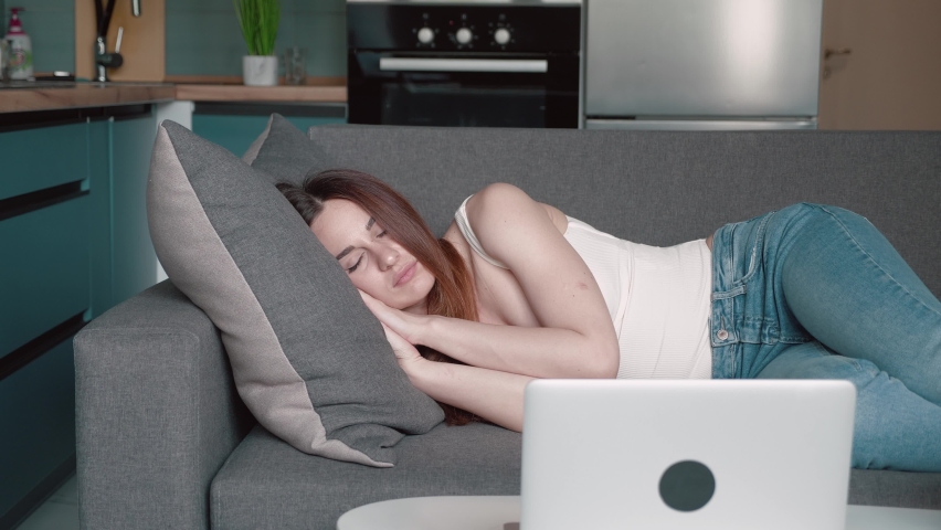 Apathetic or bored young sleepy woman falls down on sofa. Exhausted tired lazy lady sleeping on couch at home alone. Funny girl lying asleep feeling lack of motivation, fatigue or depression concept | Shutterstock HD Video #1076073887