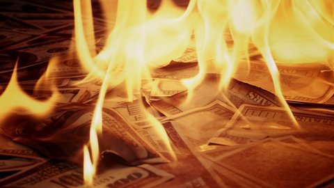 Burning of American hundred dollar banknotes. Flame of fire from a pile of cash. Financial crisis and depressed economy. Paper money loss concept. 