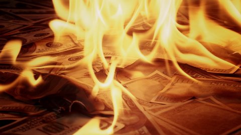 Burning of American hundred dollar banknotes. Flame of fire from a pile of cash. Financial crisis and depressed economy. Paper money loss concept. 