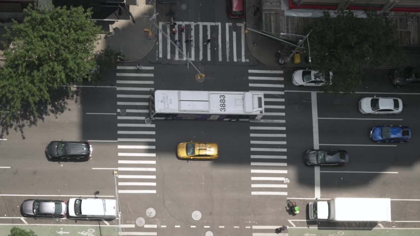 A top down aerial view of a busy Manhattan street during the day.  	 Royalty-Free Stock Footage #1076083412