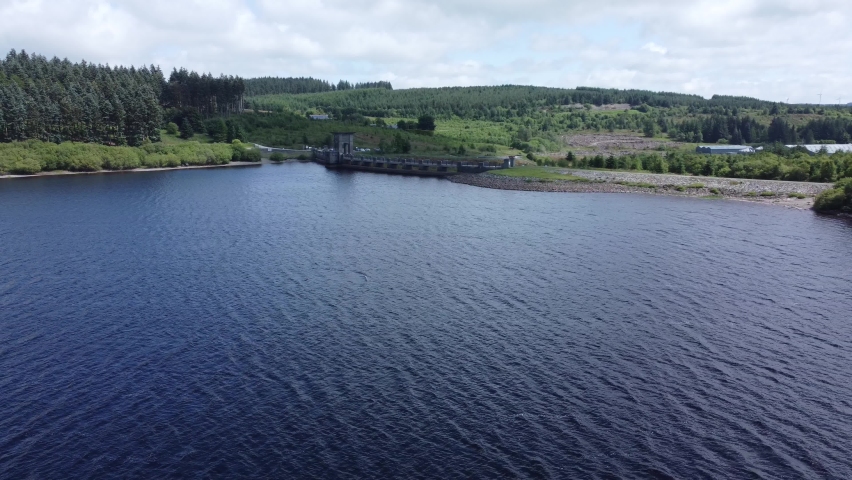 Picturesque blue water reservoir lake woodland hiking walk aerial view pull away