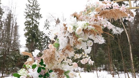 Close-up of fresh flowers that adorn the wedding arch during the event in winter. Cool decor item