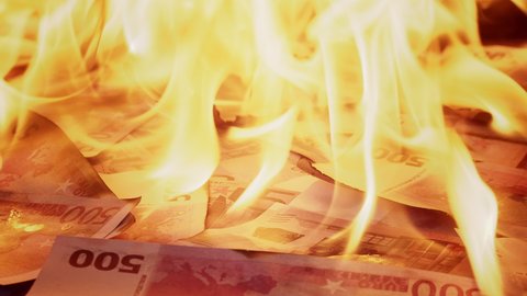 Burning of 500 euro banknotes close-up. Flame of fire from a pile of cash. Financial crisis and depressed economy. Paper money loss concept. 