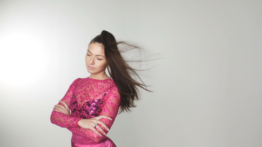 Portrait of beautiful woman in red dress fluttering in wind. Fabric waving in the wind. Fashionable image for advertising perfumes or other concepts