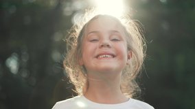 Happy girl in rays of the sun. Girl face in park close-up. Dream girl. Happy face of a child in rays of sun. Child smiles at camera. Girl dream. Face close-up. Happy child in park.Beautiful face - Powered by Shutterstock - Get 15% off with code: PIKWIZARD15