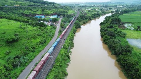 Aerial footage of a freight train heading towards Mumbai next to the Indrayani river at Kamshet, near Pune India.