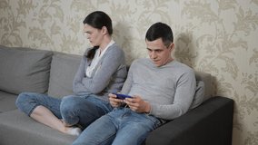 Man plays games on smartphone and girlfriend is dissatisfied