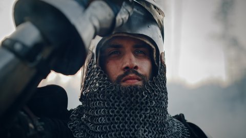 Medieval Knight on Battlefield, Looking at Camera, Closes his Helmet for Battle. Portrait of Mighty Warrior, King, Soldier at War, Conquest, Crusade. Dramatic Scene, Cinematic Historic Reenactment