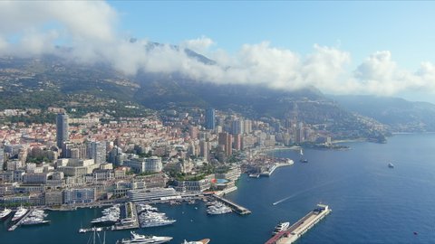 Monte Carlo, Monaco. Aerial view of famous city towering over Mediterranean Sea, Monte Carlo Casino in center of city, marina Port Hercules, blue sky - landscape panorama of Europe from above