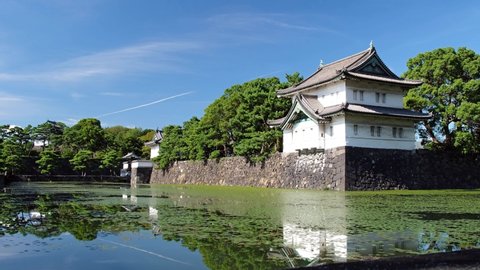 Video of the Kikyo-bori moat overgrown with water plants around the Tokyo Imperial Palace outer wall with the Edojo Sakurada Tatsumi Yagura guard tower on the background. Tokyo. Japan
