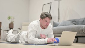 Man Talking on Video Call on Laptop Yoga Mat at Home