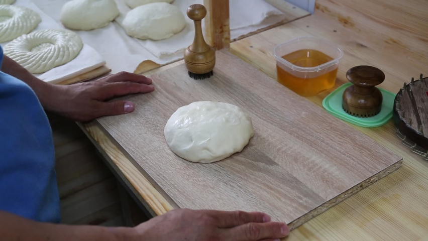 Preparing the dough with your hands for baking Uzbek flatbread in a tandoor. Bakery products national traditional dishes and pastries. Royalty-Free Stock Footage #1076148845