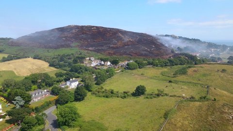 Aerial view over the remains of a gorse wildfire in the Shelmartin area of Howth in north county Dublin in Ireland. Thick plumes of smoke around the hill of Howth.
