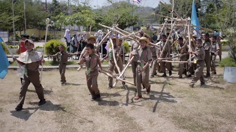 Yala, Thailand March 11, 2016  Thai Boy Scout activities excited joyful boys and girls teams bring hand made wooden catapult, happy and fun, Muslim Students Ban Yala primary school. Slow motion