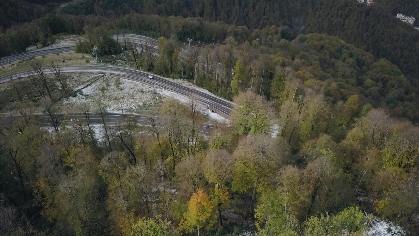 The mountain highway winds from side to side forming a pattern in the mountains. Shooting from the air Royalty-Free Stock Footage #1076154056