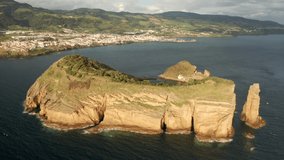 Drone flying over green Islet of Vila Franca do Campo, Sao Miguel Island, Azores, Portugal, Europe. Panoramic view of astonishing landscape of rocky islet formed by volcano, 4k footage