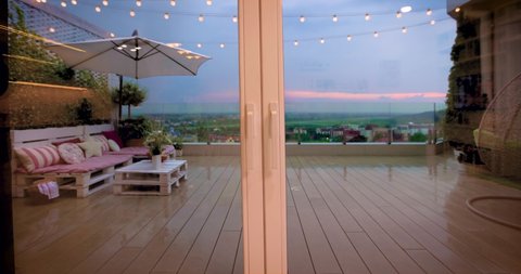 opening wooden sliding doors, going to rooftop patio with lounge zone and beautiful city scape