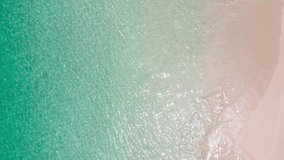 Aerial view shot of drone. Top-down view full frame beach sand and water texture and clear. Nature and travel concept. 4K UHD Video clip.