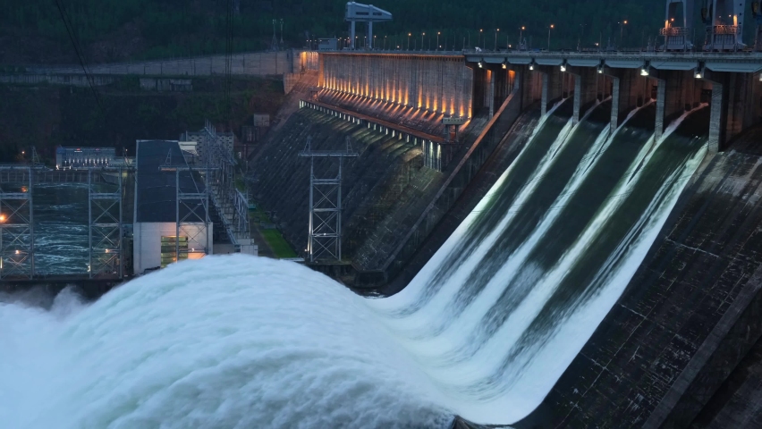 View of the hydroelectric dam, discharge of water through the locks, filming at dusk