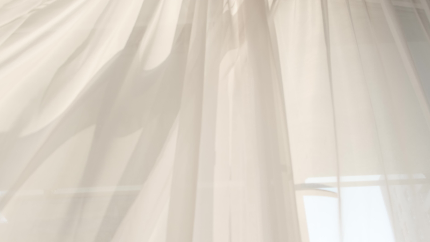 Transparent white curtain tulle moves from the wind from an open window. Sunny day, the sun's rays sunlight. Royalty-Free Stock Footage #1076178551