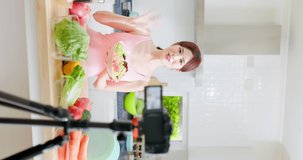 vertical of asian Fitness woman records training on vegetarian cooking - Distances diet through camera video tutorial