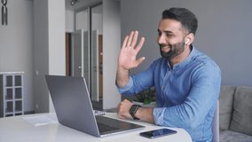Adult indian man wearing wireless earphones make business internet video call conference looking at laptop screen. Middle age eastern businessman consult client in online chat in home office, trading - Powered by Shutterstock - Get 15% off with code: PIKWIZARD15
