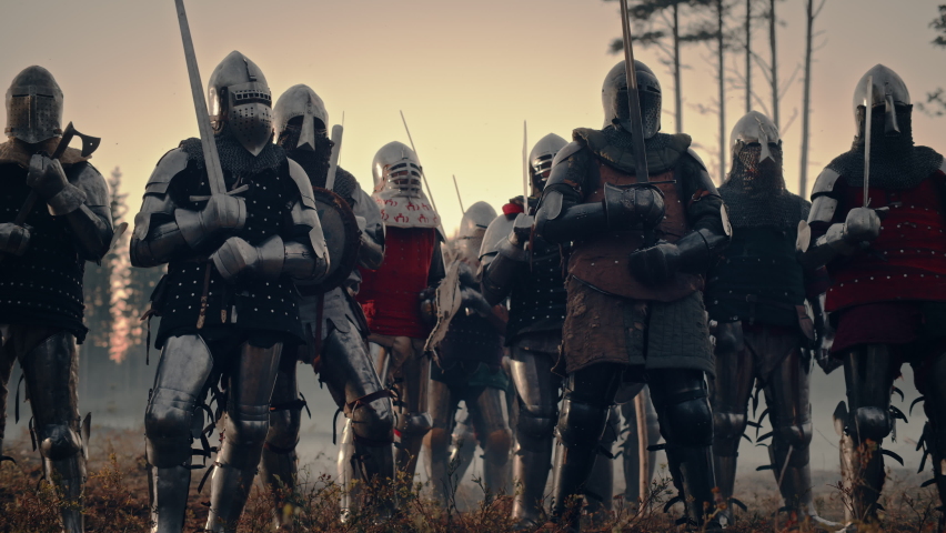 Epic Invading Army of Medieval Knights on Battlefield. Armored Soldiers in Helmets, With Shields and Swords ready for the Battle. War, Conquest, Crusade. Historical Reenactment. Cinematic Wide Shot Royalty-Free Stock Footage #1076193314