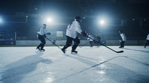 Ice Hockey Rink Arena: Professional Forward Player Masterfully Dribbles, Breaks Defense, Hitting Puck with Stick Scores Goal, Goalie Missed it. Team Celebrates. Cinematic Slow Motion Wide Shot