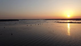 a short 4k aerial video of Poole Harbour at Sandbanks showing a paddleboarder at sunset 