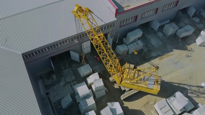 The yellow crane puts granite block in stone storage. Modern granite manufacture. Stone industry Royalty-Free Stock Footage #1076200145