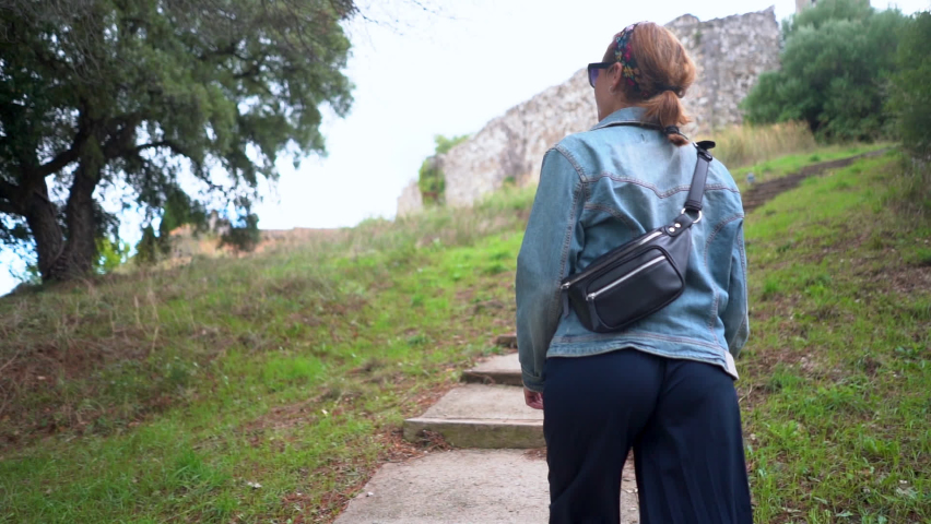 Caucasian woman climbing some stairs that reaches the mountain.HD proress