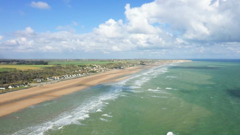 The landing beach of Omaha beach dominated by its immense cliffs in France, Normandy, Calvados, at the edge of the Channel, in spring.