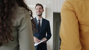 Joyful real estate broker is giving keys to happy customers man and woman shaking hands indoors in new house. Lifestyle and business deals concept. - Powered by Shutterstock - Get 15% off with code: PIKWIZARD15