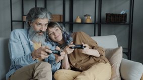 People couple enjoying video game celebrating victory doing high-five and laughing playing during leisure time at home. Activities and emotions concept.