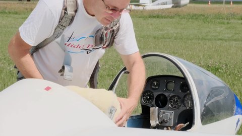 Buzova, Kyiv, Ukraine - 07.07.2021 Mature glider pilot in the airplane before flight. Looking at control panel or aircraft on the land. fixed-wing plane without motor. Soaring sport