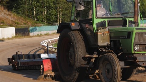 BORAS, SWEDEN - JULY 17, 2021: Close view of tractor preparing the greyhound racing track one sunny evening in the summer. 4K footage, slowmotion x2.