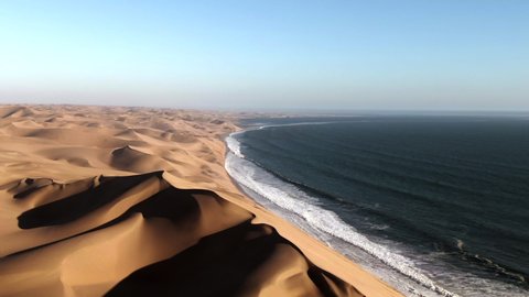 Aerial view of Sandwich Harbour, where towering sand dunes meet the Atlantic coast, near Walvis Bay in the Namib-Naukluft National Park, Namibia.