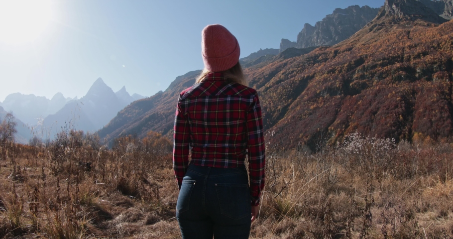 Young woman enjoying in the autumnal mountains. Mountain and happy tourist