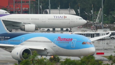 PHUKET, THAILAND - NOVEMBER 27, 2017: Boeing 787-8 Dreamliner of TUI, G-TUIF preparing to take off from Phuket airport, Thailand. Rainy weather, view of the airport runway