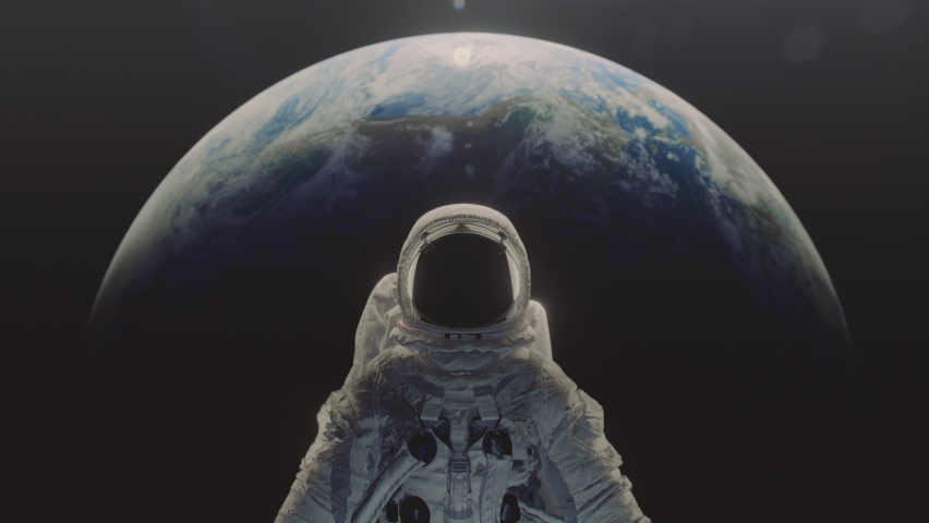 Dolly in shot of an astronaut with planet Earth n the background. | Shutterstock HD Video #1076209979