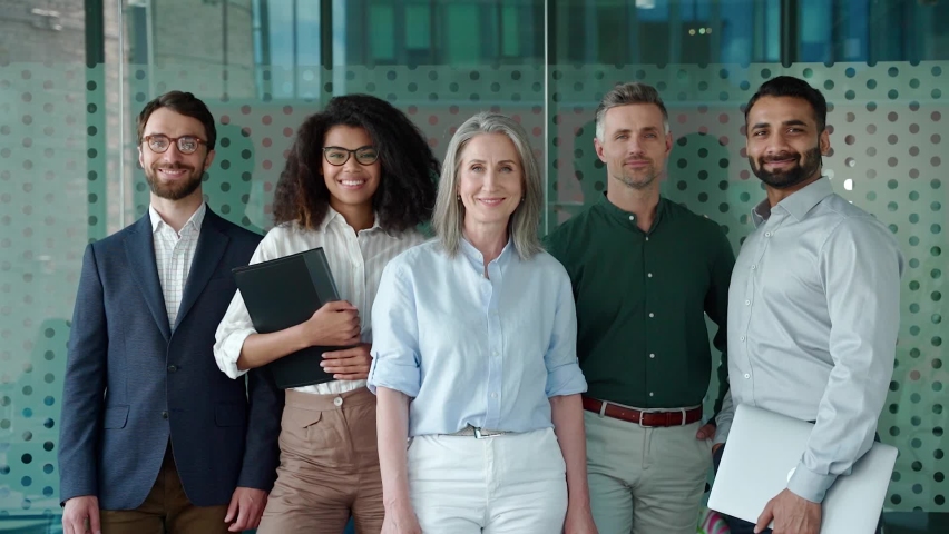 Happy diverse business people office workers team standing in row looking at camera. Multiethnic professional employees executives group posing together for corporate portrait, leadership. Slow motion Royalty-Free Stock Footage #1076215751